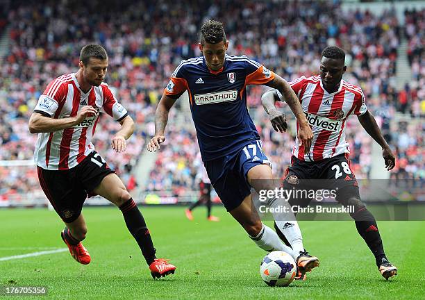 Ondrej Celustka and Stephane Sessegnon of Sunderland in action with Matthew Briggs of Fulham during the Barclays Premier League match between...