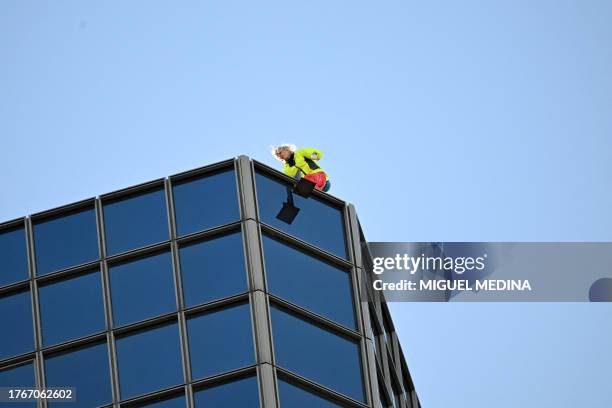 French skyscraper climber Alain Robert, known as the "French Spiderman", arrives on the top after climbing the Coupole Total tower in Puteaux at La...