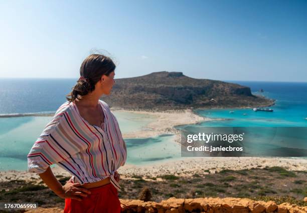 female tourist visiting balos beach. hot summer weather and sapphire blue water - crete scenics stock pictures, royalty-free photos & images