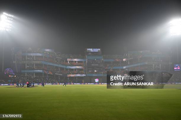 Sri Lanka's players arrive on the field amid smoggy conditions during the 2023 ICC Men's Cricket World Cup one-day international match between...