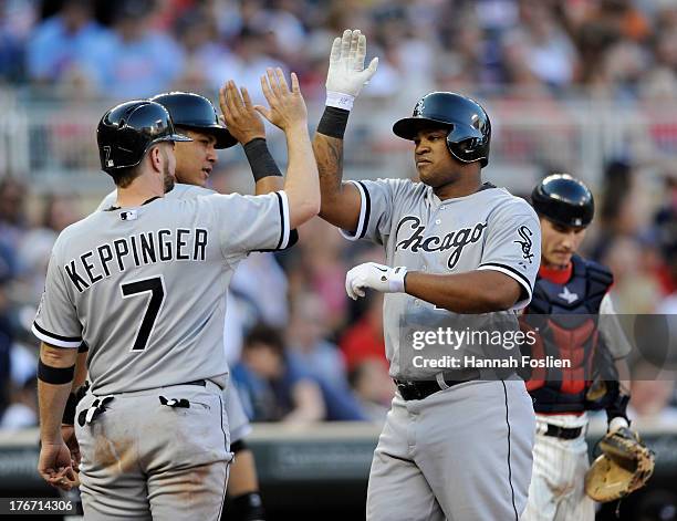 Jeff Keppinger and Avisail Garcia of the Chicago White Sox congratulate teammate Dayan Viciedo on a three run home run as Chris Herrmann of the...