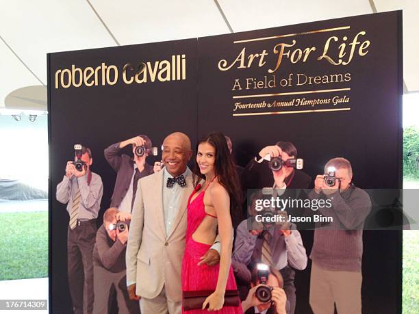Russell Simmons and model Hana Nitsche pose circa July 2013 in New York City.