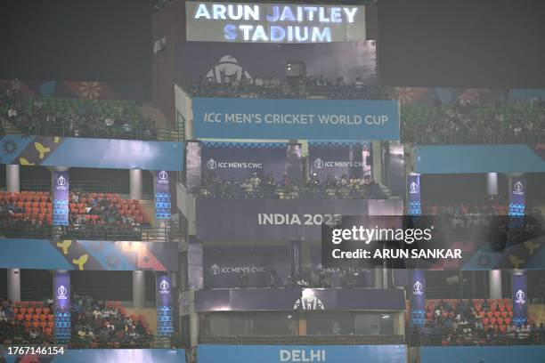 Spectators watch the 2023 ICC Men's Cricket World Cup one-day international match between Bangladesh and Sri Lanka, amid smoggy conditions at the...