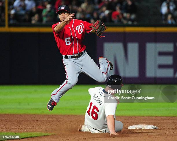 Anthony Rendon of the Washington Nationals turns a double play against Brian McCann of the Atlanta Braves at Turner Field on August 17, 2013 in...