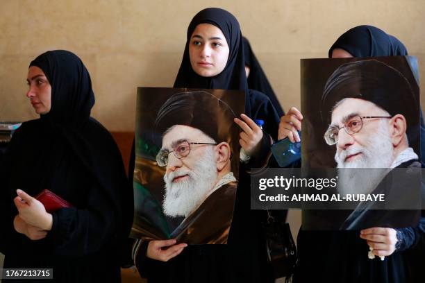 Women hold pictures Iran's Supreme Leader, Ayatollah Ali Khamenei during the funeral of a Hezbollah member who was killed in southern Lebanon in...