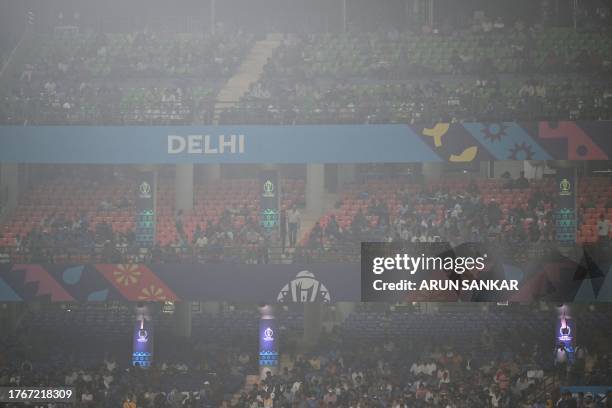 Spectators watch the 2023 ICC Men's Cricket World Cup one-day international match between Bangladesh and Sri Lanka, amid smoggy conditions at the...