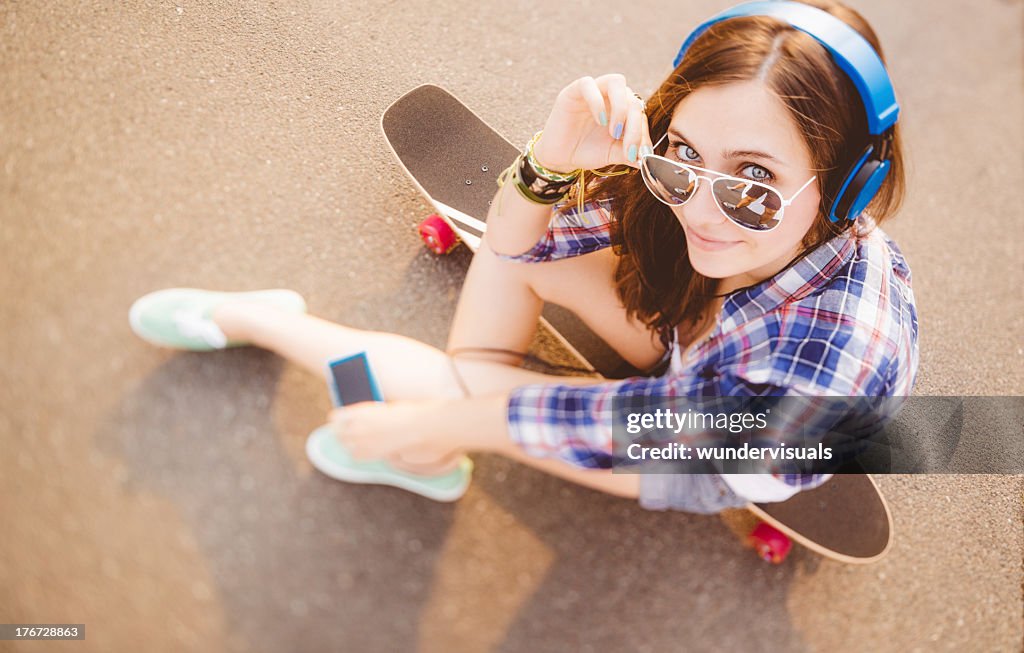 Skater Girl listening to music and looking up at camera