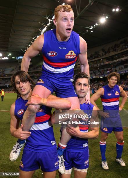 Adam Cooney of the Bulldogs gets lifted up after winning his 200th game by Ryan Griffen and Daniel Giansiracusa during the round 21 AFL match between...