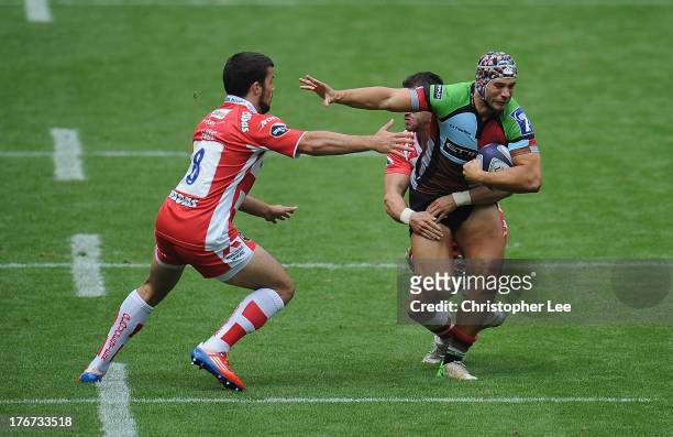 Jack Clifford of Harlequins is tackled by Matt Cox of Gloucester as he holds off Gareth Evans during the Cup Semi Final match between Gloucester and...
