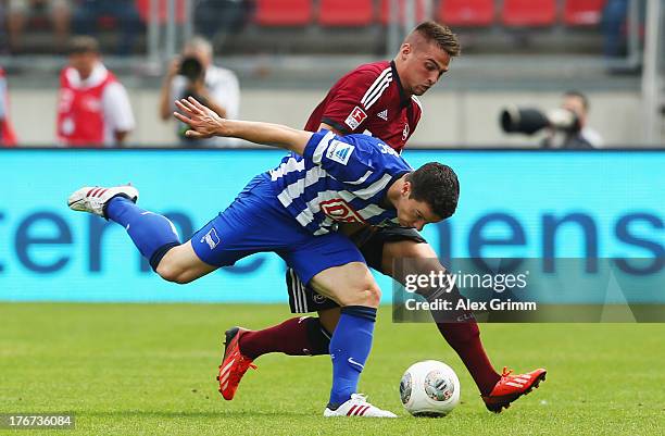 Alexander Baumjohann of Berlin is challenged by Niklas Stark of Nuernberg during the Bundesliga match between 1. FC Nuernberg and Hertha BSC Berlin...