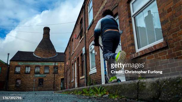 Boy plays in the street near the Heron Cross pottery kiln on October 31, 2023 in Stoke on Trent, England Government figures show that Stoke on Trent...