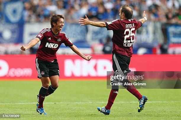 Hiroshi Kiyotake of Nuernberg celebrates his team's second goal with team mate Javier Pinola during the Bundesliga match between 1. FC Nuernberg and...