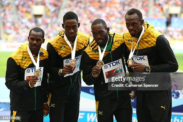 Gold medalists Nickel Ashmeade, Nesta Carter, Kemar Bailey-Cole, and Usain Bolt of Jamaica pose on the podium during the medal ceremony for the Men's...