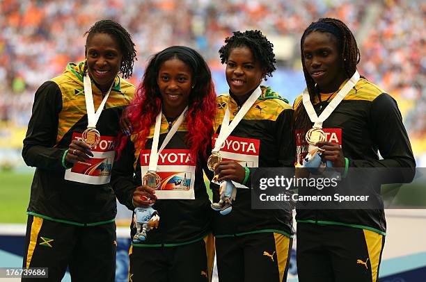 Nickiesha Wilson, Carrie Russell, Schillonie Calvert and Shelly-Ann Fraser-Pryce of Jamaica pose on the podium during the medal ceremony for the...