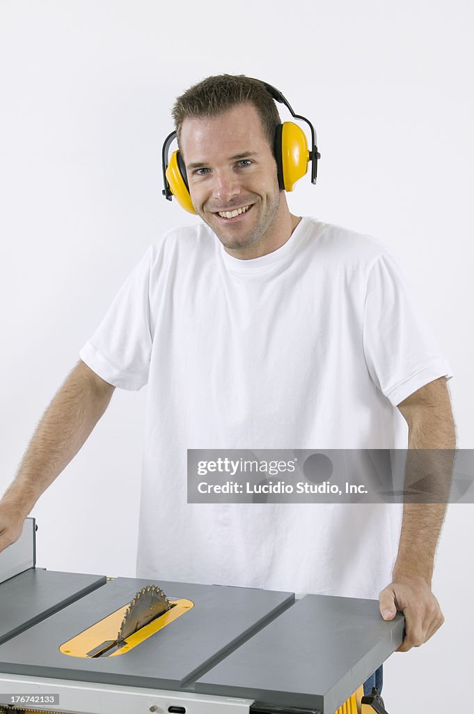 DIY guy standing beside his table saw