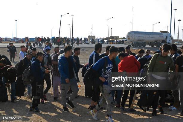 Afghan immigrants deporting back from Iran, carry their belongings at a registration centre in the Islam Qala border town of Herat province on...