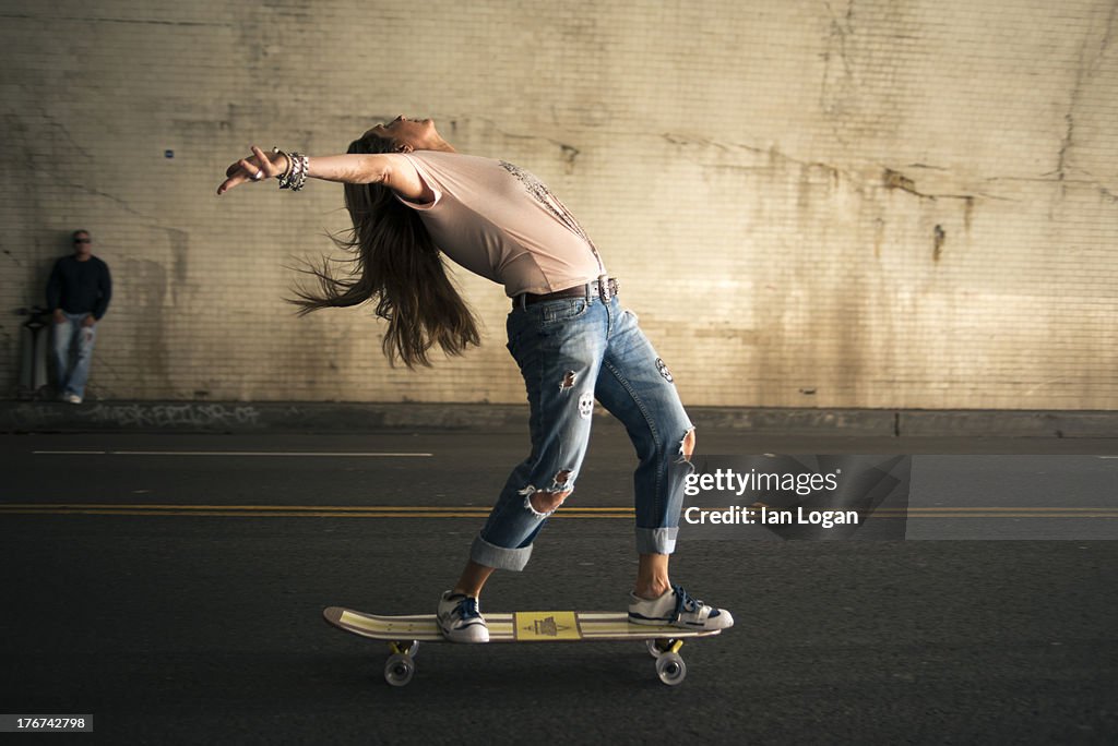 Woman skateboarding in tunnel