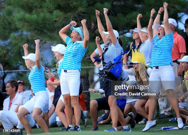 Suzann Pettersen of Norway, Caroline Hedwall of Sweden and the European Team celebrate as Karine Icher clinched the final match on the 18th green...