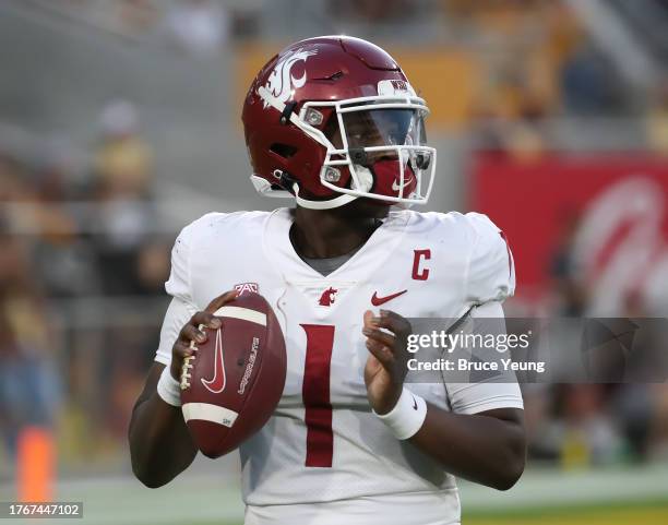 Cameron Ward of the Washington State Cougars takes some practice throws on the sidelines during a timeout in the first quarter against the Arizona...