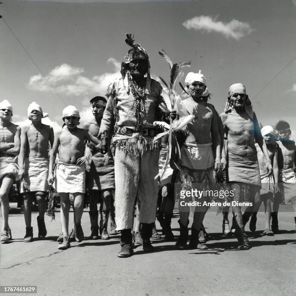 Low-angle view of a group of men and boys , some with dried mud on their bodies, as they participate in a parade, Gallup, New Mexico, mid twentieth...