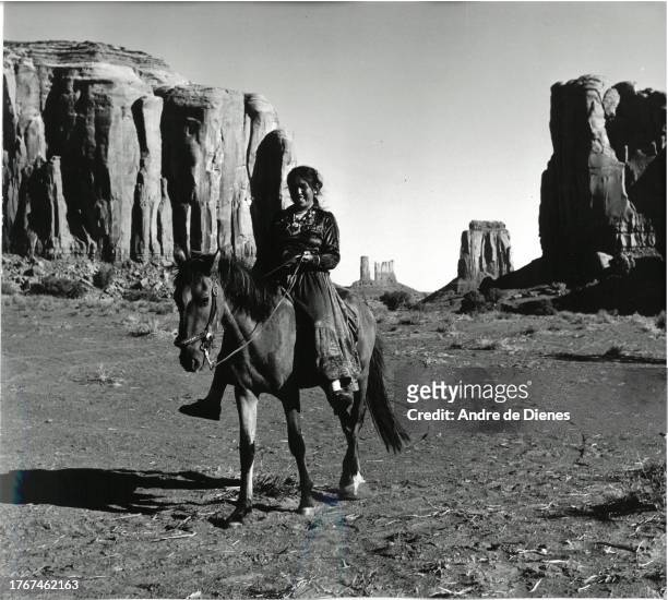 Portrait of a woman as she smiles from horseback in the Oljato-Monument Valley, Arizona, mid twentieth century.