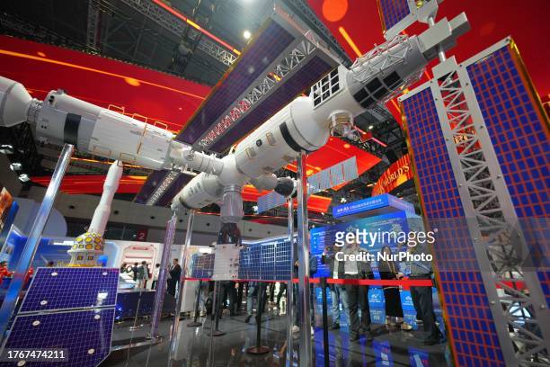 Visitors look at a model of China's space station at the China Pavilion of the Sixth National Comprehensive Exhibition of the International Import...
