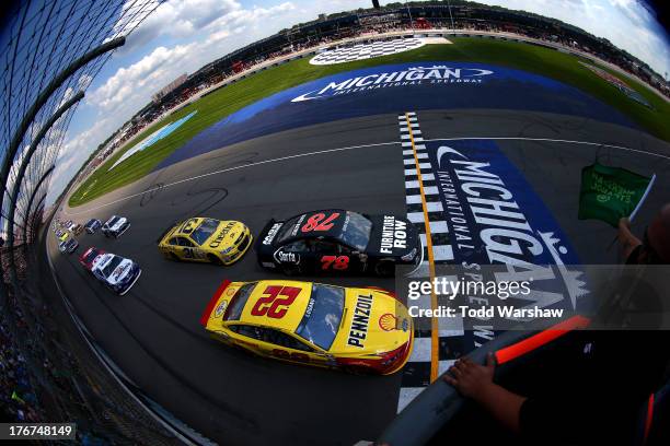 Joey Logano, driver of the Shell-Pennzoil Ford, and Kurt Busch, driver of the Furniture Row / Serta Chevrolet, lead the field to the start of the...