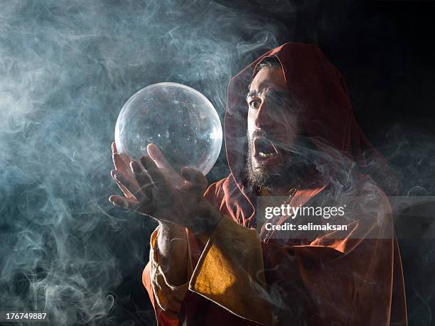 fortune teller in fantastical costume holding crystal ball - man in period costume stock pictures, royalty-free photos & images
