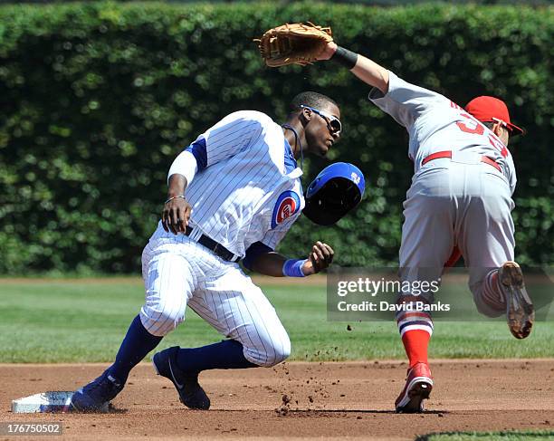 Daniel Descalso of the St. Louis Cardinals forces out Junior Lake of the Chicago Cubs during the first inning on August 18, 2013 at Wrigley Field in...