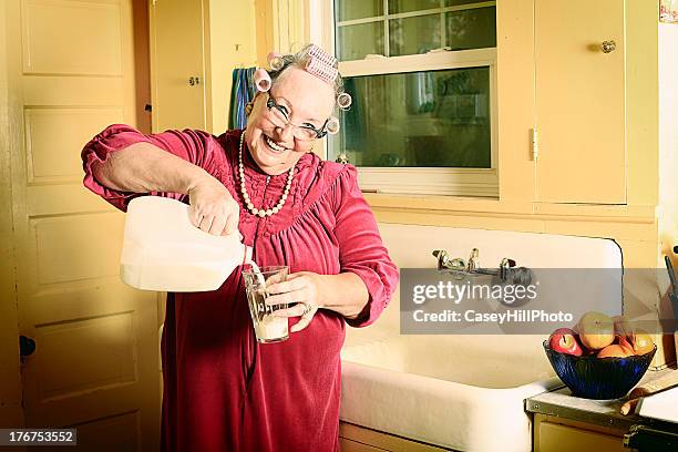 granny in kitchen pouring milk - milk bottle stock pictures, royalty-free photos & images