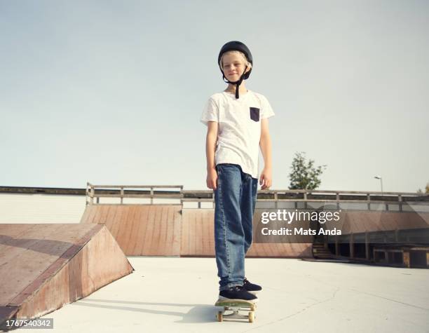 skaterboy in skatepark with his skateboard - boys sport pants stock pictures, royalty-free photos & images