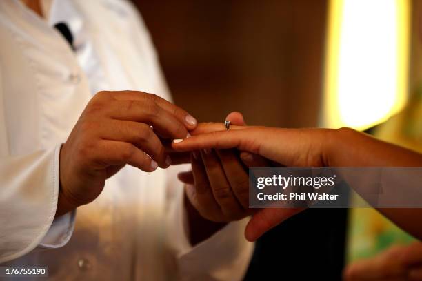Natasha Vitali and Melissa Ray exchange rings with marriage celebrant Rev Matt Tittle at the Auckland Unitary Church on August 19, 2013 in Auckland,...