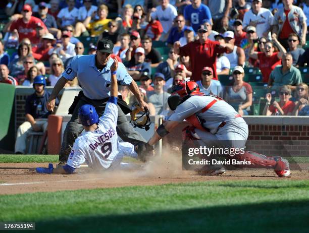 David DeJesus of the Chicago Cubs is tagged out at home by Yadier Molina of the St. Louis Cardinals during the eighth inning on August 18, 2013 at...