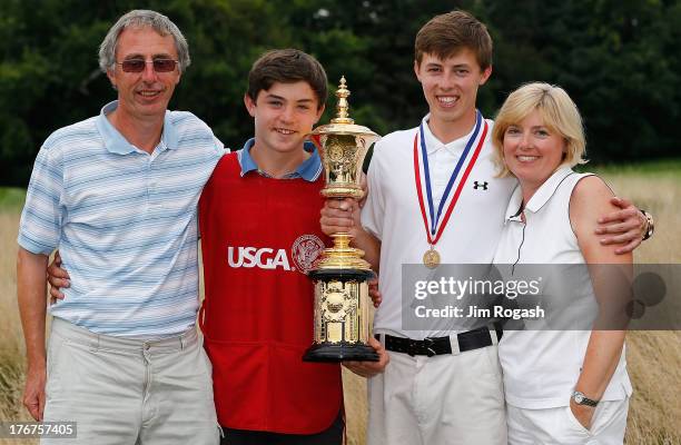 Matt Fitzpatrick of England holds the Havemeyer trophy with father Russell, his brother Alex Fitzpatrick, and his mother Sue after hewinning the 2013...