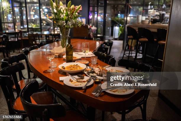 Tables with food and drinks are left unattended after people run towards a bomb shelter after a red alert siren goes off when a rocket is fired from...