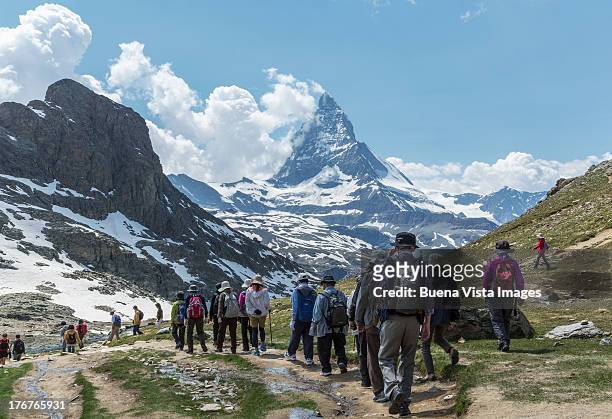 tourists walking toward matterhorn - matterhorn stock pictures, royalty-free photos & images