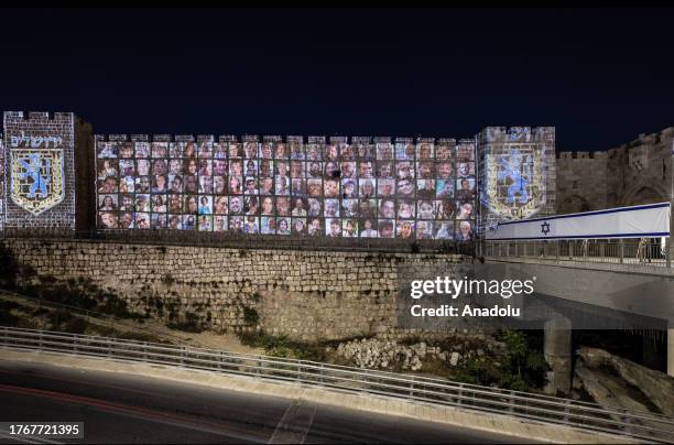 Photographs of Israelis taken hostage by Hamas in the Gaza Strip, are reflected on the walls of Jerusalem at the Old City in Jerusalem on November...