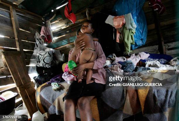 Picture taken 21 December 2005 shows a south African mother holding her child in her shack in central Durban. From the slums of Durban, a new...