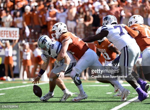 Kansas State Wildcats QB Will Howard fumbles while being sacked by Texas Longhorns DE Ethan Burke during the college football game between the Kansas...