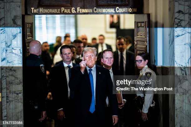 New York, NY Former President Donald Trump gestures a zipped lip as he walks out of the courtroom during a break before testifying in his civil fraud...