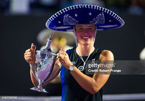 Iga Swiatek of Poland poses with the champions trophy after defeating Jessica Pegula of the United States in the final of the GNP Seguros WTA Finals...