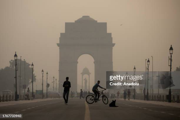 Commuters make their way past the India Gate amid smoggy conditions in New Delhi, India on November 07, 2023. Air Quality Index between 401 and 500...