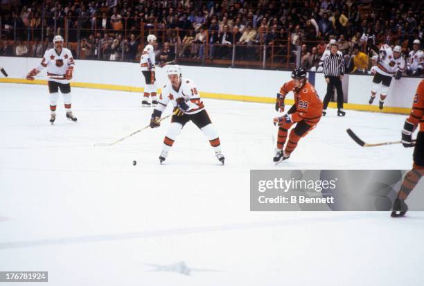 Marcel Dionne of the Wales Conference and Los Angeles Kings skates with the puck as Wayne Gretzky of the Campbell Conference and Edmonton Oilers...