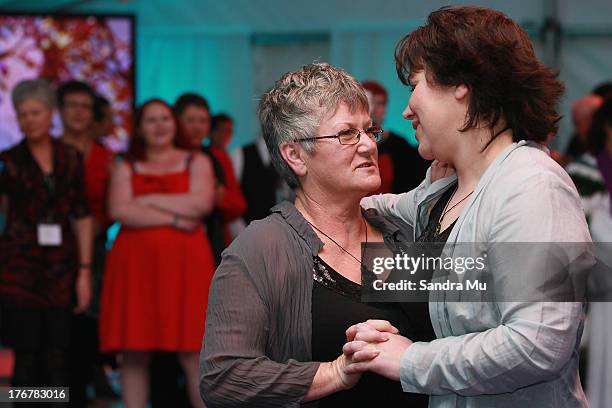 Newly wed couple Ally Wanikau and Lynley Bendall share their first dance during the reception inside the Air New Zealand hanger on August 19, 2013 in...