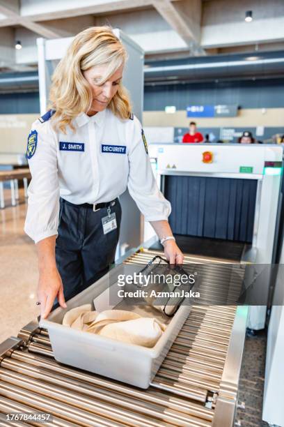 adult caucasian female airport security guard checking  the x-ray machine - border control stock pictures, royalty-free photos & images