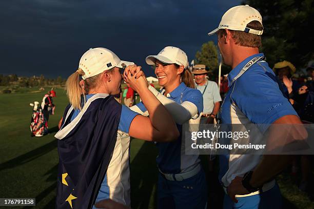 Jodi Ewart-Shadoff of England and the European Team celebrates with Azahara Munoz of Spain and the European Team and Mounoz's caddie Tim Vickers...