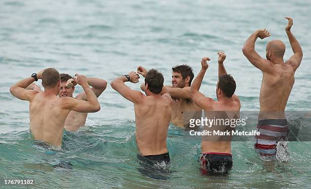 Swans players wade in the ocean during a during a Sydney Swans AFL recovery session at Coogee Beach on August 19, 2013 in Sydney, Australia.