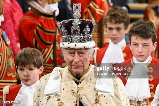 Britain's King Charles III, wearing the Imperial State Crown and the Robe of State, processes through the Royal Gallery during the State Opening of...