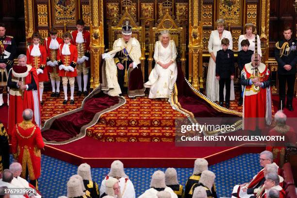 Britain's King Charles III, wearing the Imperial State Crown and the Robe of State, and Britain's Queen Camilla, wearing the George IV State Diadem,...