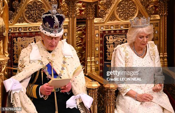 Britain's Queen Camilla, wearing the George IV State Diadem, looks at her nails as Britain's King Charles III, wearing the Imperial State Crown and...